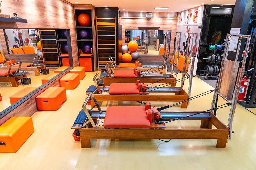 Turma em aula de Pilates nos aparelhos reformer no estúdio da Clínica da Coluna, em Maringá