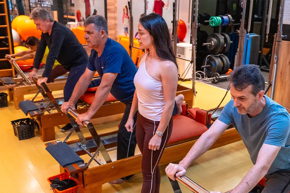 Fileira de aparelhos reformer no estúdio de Pilates da Clínica da Coluna, em Maringá